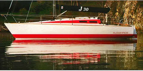 J/30 at rest in calm water with its J/30 sail cover on the boom