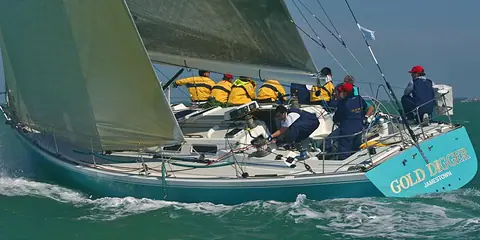 J/44 racing upwind with crew working in the cockpit and on the rail
