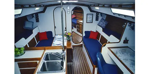 J/44 saloon with blue settees, galley sinks and teak and holly sole