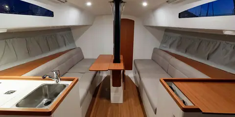 J/99 main cabin with settees, a drop leaf table and the galley sink