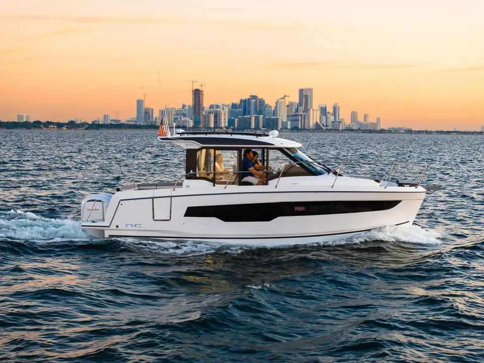 Jeanneau NC 895 running at speed at sunset with the Miami skyline behind
