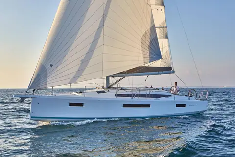 Jeanneau Sun Odyssey 410 sailing in profile under main and genoa in evening light