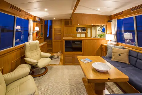 Krogen Express 52 saloon with teak joinery, recliners and a settee by the windows