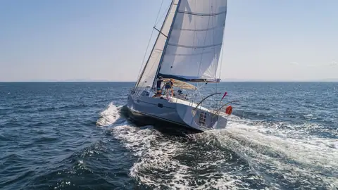 Kraken 50 seen from astern sailing at speed with its center cockpit and transom visible