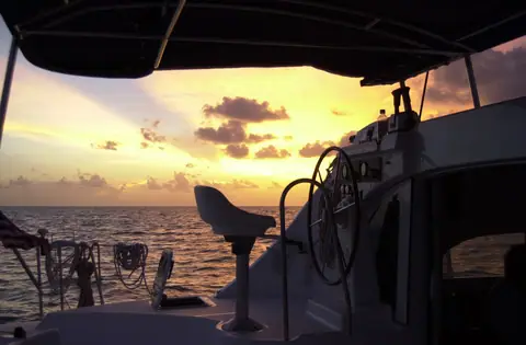 Helm and cockpit of a Lagoon 380 catamaran at sunset