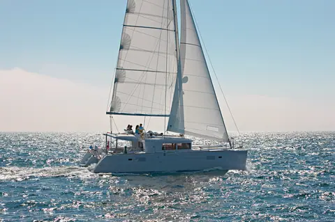 Lagoon 450 sailing in profile under main and jib on a sunny day