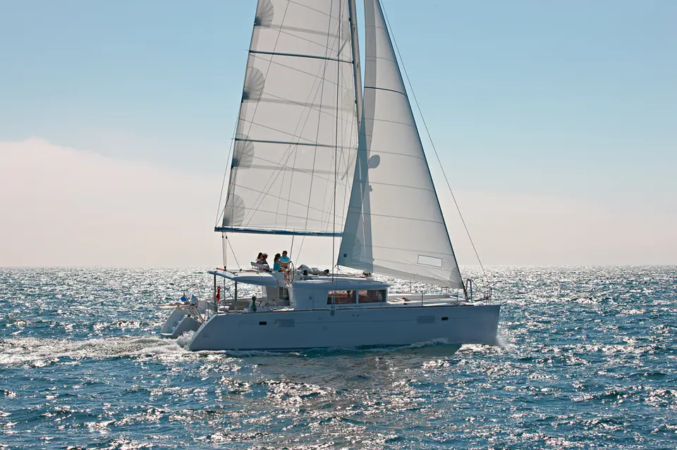 Lagoon 450 sailing in profile under main and jib on a sunny day