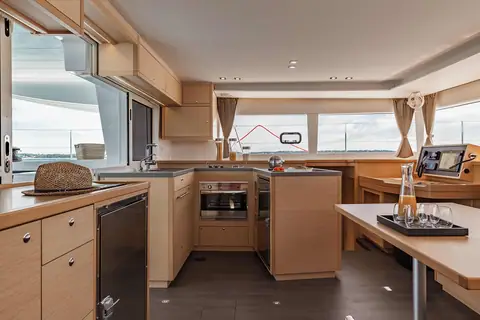 Lagoon 450 saloon with a galley, light oak joinery and a chart table by the windows