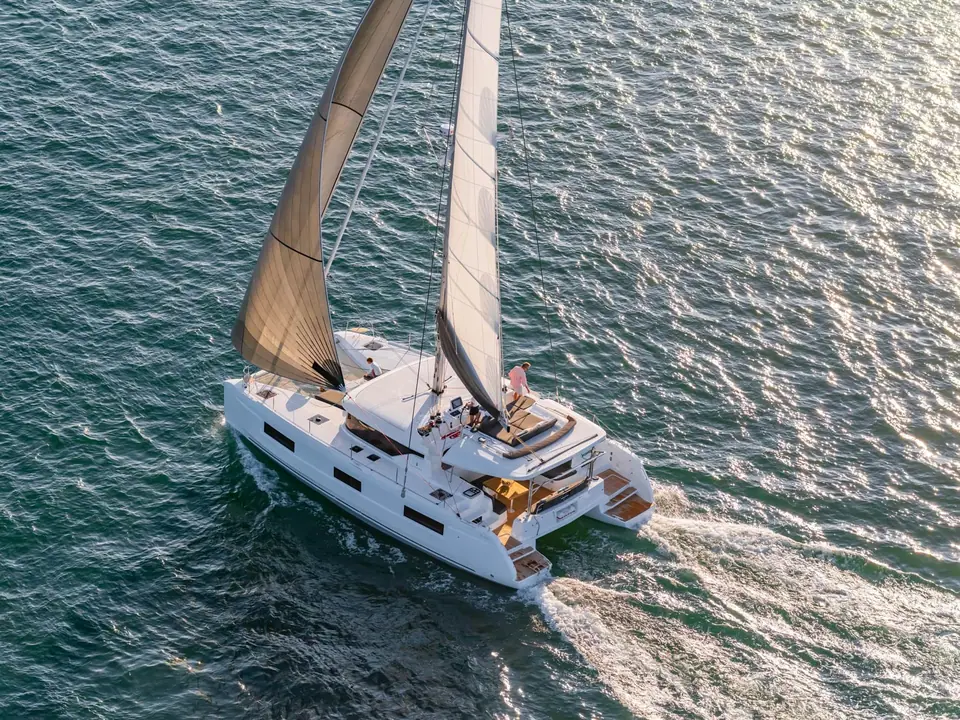 Lagoon 46 seen from above sailing at speed with its flybridge and twin hulls visible