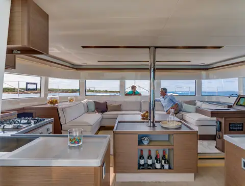 Lagoon 50 saloon with an island galley, U shaped settee and wraparound windows
