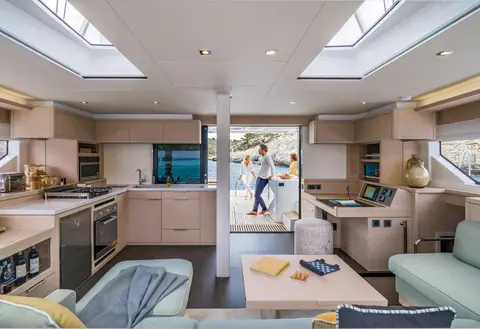 Lagoon 55 saloon and galley with overhead hatches and the cockpit door open astern