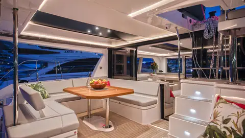 Leopard 45 cockpit with a teak table, L shaped settee and steps up to the flybridge