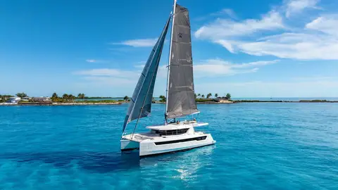 Leopard 46 catamaran sailing over turquoise water under a dark mainsail and jib