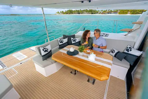 Leopard 46 aft cockpit with a teak dining table, L shaped settee and steps up to the flybridge