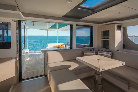 Leopard 50 saloon dinette beside an open glass door to the deck