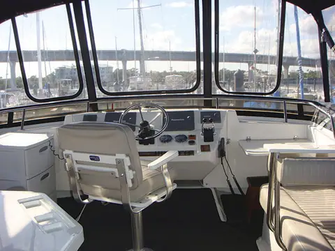 Enclosed flybridge helm of a Mainship 430 Trawler with a pedestal helm chair