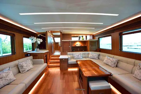 Marlow Explorer 58E saloon with teak joinery, U shaped settee, coffee table and steps to the pilothouse