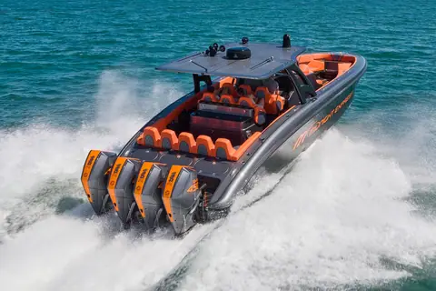 Midnight Express 43 Open with orange outboards and seating carving through a turn