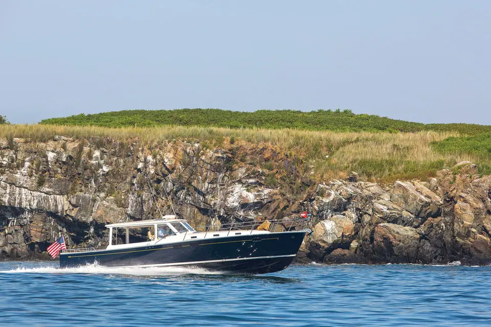 MJM 50z running along a rocky shoreline in profile