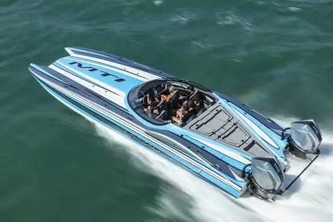Blue and white MTI 390X catamaran running hard with its tunnel hull lifting