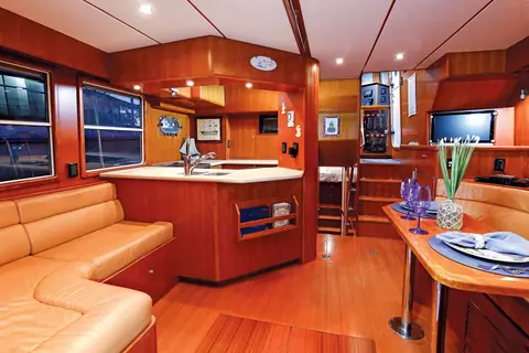 Nordhavn 40 salon with leather settee, teak joinery and the galley forward