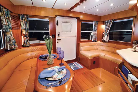 Nordhavn 40 salon dinette set for dinner with the side deck door beyond