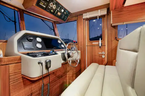 Nordhavn 41 pilothouse helm with wheel, gauges and a helm bench