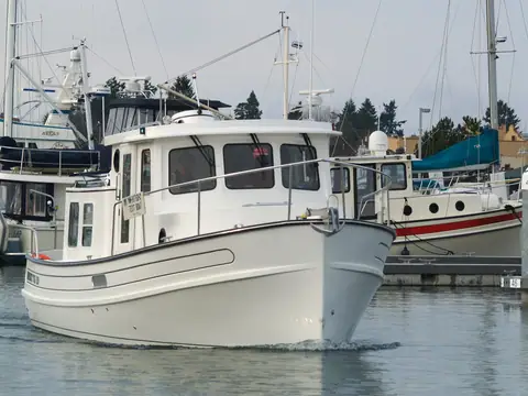 Nordic Tug 26 approaching bow on in a marina, showing the plumb bow and pilothouse