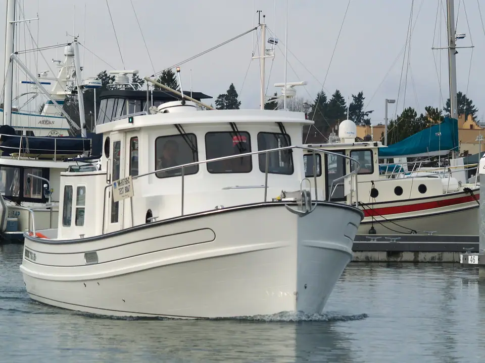 Nordic Tug 26 approaching bow on in a marina, showing the plumb bow and pilothouse