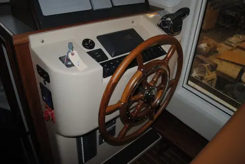 Nordic Tug 26 pilothouse helm with a wooden wheel and Garmin displays