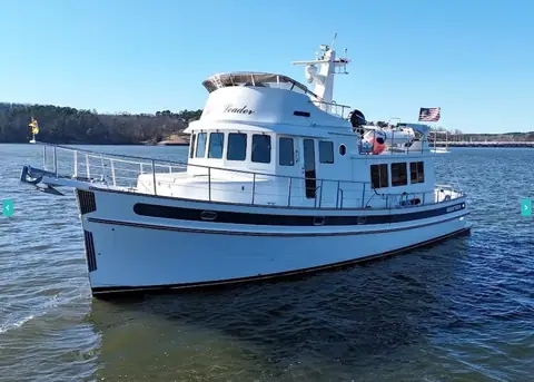 Nordic Tug 54 with a white hull and blue stripe at slow speed on open water