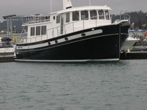 Nordic Tug 54 with a black hull tied up in a marina showing its flybridge