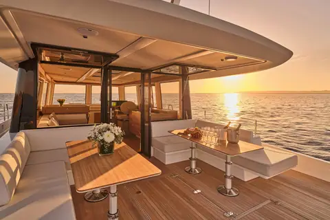 Omikron OT60 aft deck dining area under the overhang at sunset