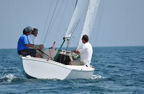 Sonar open cockpit with three crew sailing upwind in a breeze