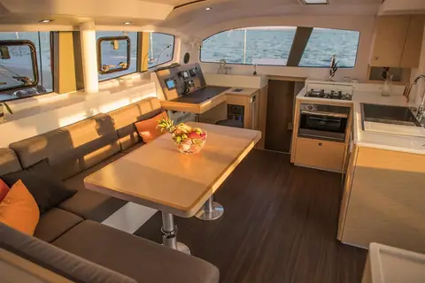 Outremer 45 saloon with dining table, galley and forward facing nav station