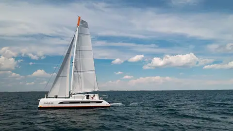 Outremer 51 sailing upwind in profile under a blue sky