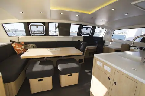 Outremer 51 saloon with dining table, galley counter and large hull windows