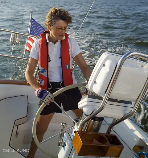 Pacific Seacraft 40 helm with a sailor steering at the wheel under sail
