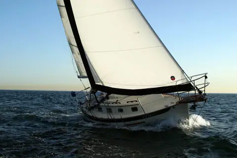 Pacific Seacraft Dana 24 heeled under sail seen from the bow quarter