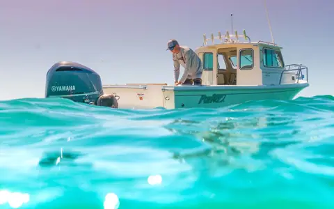 Parker 2320 Sport Cabin at rest with a Yamaha outboard and an angler on deck