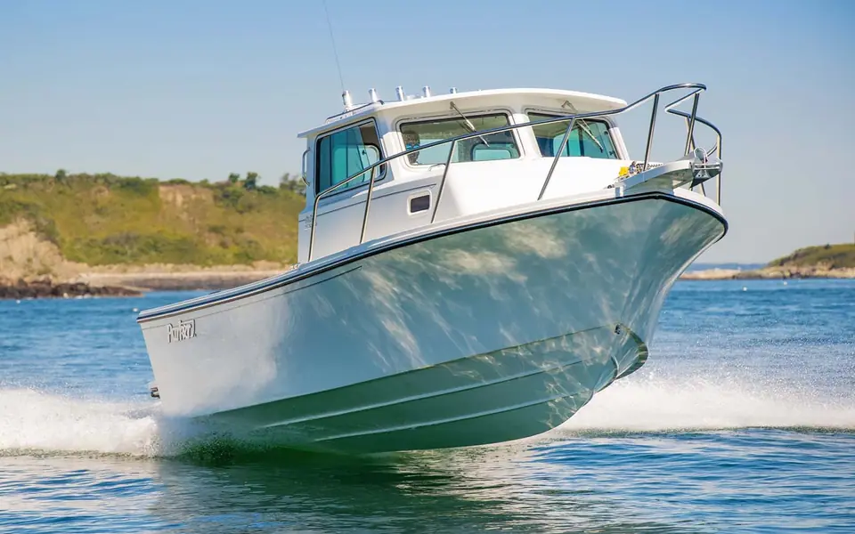 Parker 2520 XLD Sport Cabin from the bow quarter running past a headland