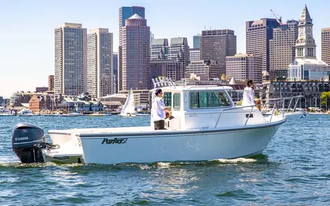 Parker 2520 XLD Sport Cabin idling in a harbor with its Yamaha outboard and crew aboard