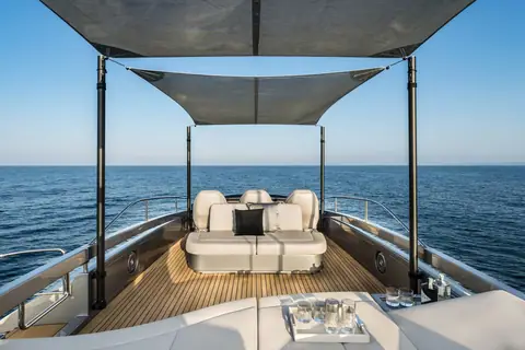 Pershing 8X deck lounge with a large sunpad under a fabric sunshade