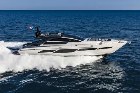 Pershing 9X running at speed in profile with its dark superstructure and wide hull windows