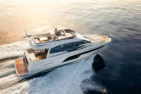 Prestige 520 running at speed seen from above the stern quarter with guests on the flybridge