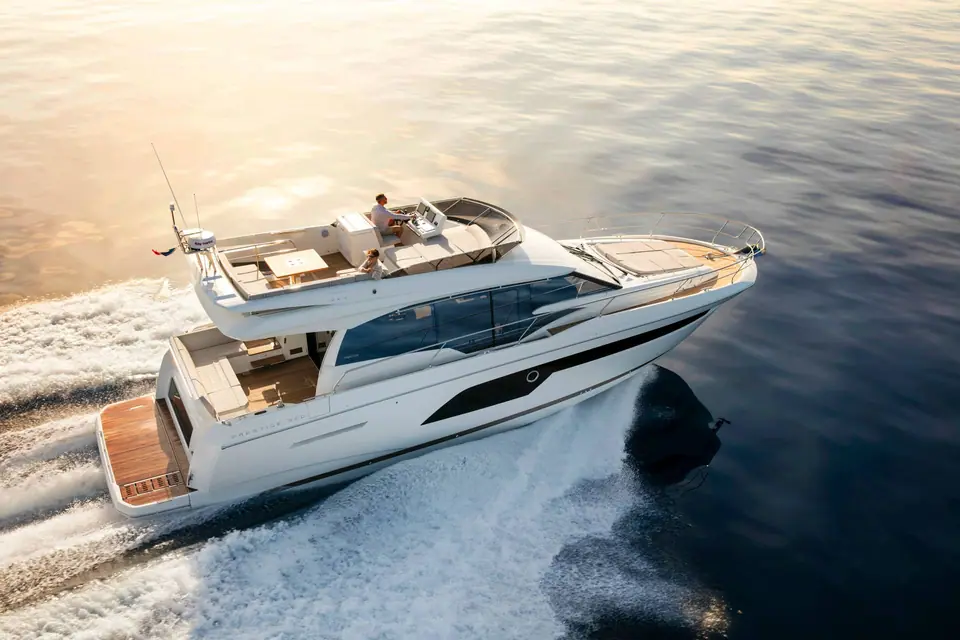 Prestige 520 running at speed seen from above the stern quarter with guests on the flybridge