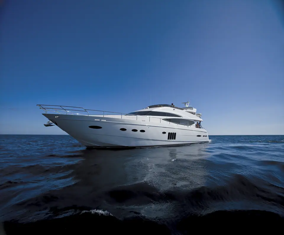 Princess 78 Motor Yacht flybridge cruiser lying still on dark open water under a blue sky
