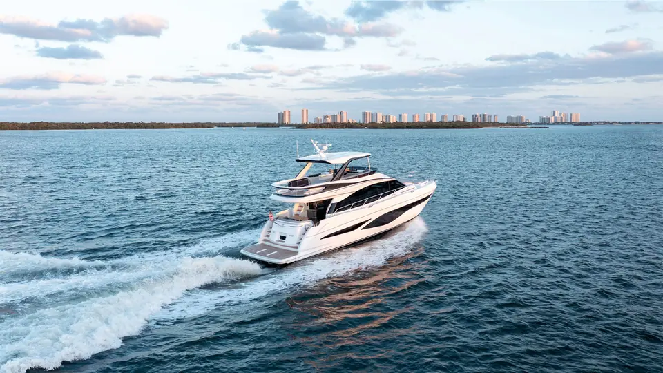 Princess F65 running at speed off a city waterfront seen from astern