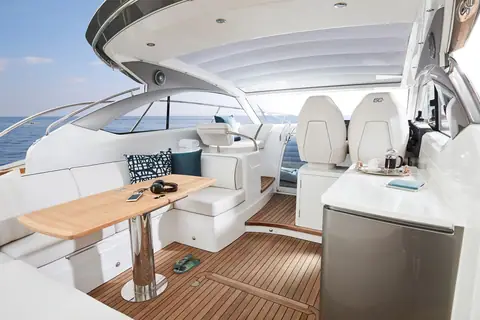 Princess V40 cockpit with teak table, wet bar and helm seats under the hardtop