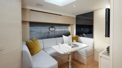 Princess V40 lower saloon with a cream settee and dining table beside the hull window